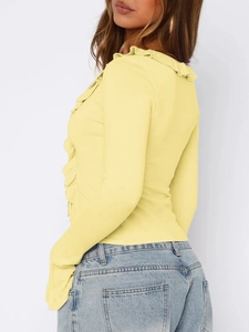 Detail view of yellow long sleeve top featuring ruffle collar and front trim decor