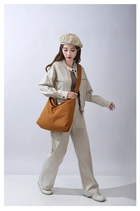 Borsa a tracolla in tela di cotone marrone mostrata su una modella in uno studio professionale