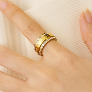 Close-up of 18k gold plated titanium ring with roman numerals and crystals on finger