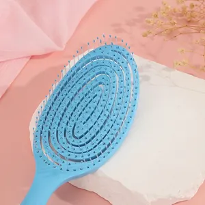 Light blue hollow spiral hair brush for scalp massage and styling on pink background