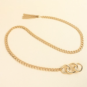 Macro shot of gold tassel pendant and interlocking rings on a metallic chain belt