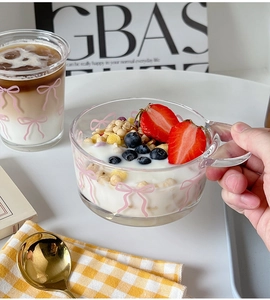Detail of a glass bowl and cup set featuring pink bow patterns used for breakfast yogurt