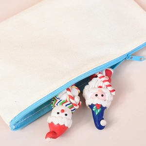 Off-white canvas zipper pouch with blue trim featuring Santa and Snowman resin charms
