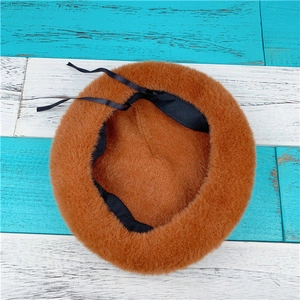 Detail view of the brown faux rabbit fur beret featuring inner lining and adjustable straps