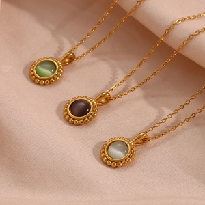 Detailed close-up of three cat eye stone sun pendants in green, purple and white with gold trim