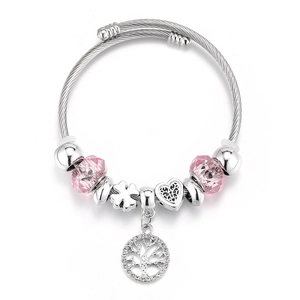 Detailed shot of silver crown charm bracelet with pink beads and tree of life pendant