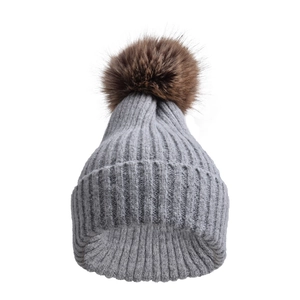 Dettaglio del berretto in maglia grigia con pompon in ecopelliccia marrone soffice