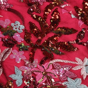 Macro detail of red lace dress showing premium floral embroidery and shiny sequins