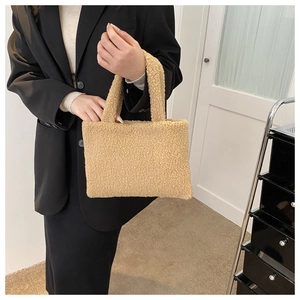 Detailed view of khaki plush handbag showing soft faux fur texture and elegant handle