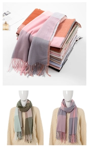 Close-up of soft plaid scarves with tassels in multiple colors like pink and grey