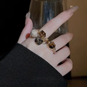 Gold plated ring set with brown crystals and tiger eye stone shown on a model