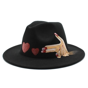 Detail of hand-painted gesture and red hearts on black wool felt fedora hat