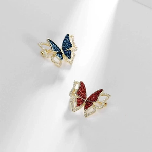 Detailed close-up of blue and red butterfly brooches with sparkling cubic zirconia inlay