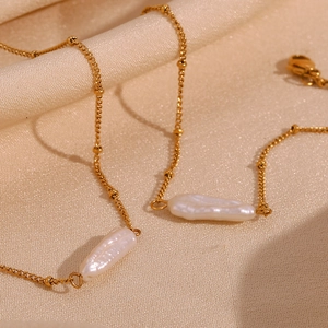 Baroque pearl pendant necklace set in 18K gold plated stainless steel on silk