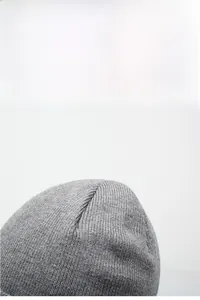 Close-up of the grey winter knit hat showing premium multi-panel top stitching detail