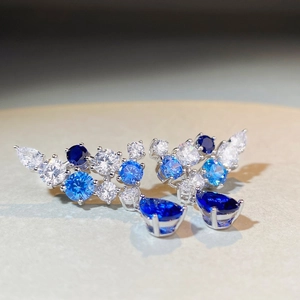 Makroaufnahme von Silberohrsteckern mit funkelnden blauen und weißen Zirkonia-Steinen