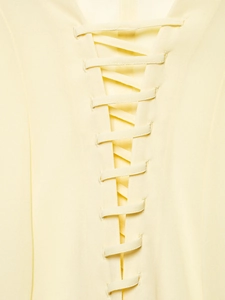 Detailed close-up of the lace-up tie design on a light yellow lightweight fabric shirt