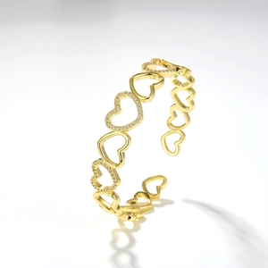 Dettaglio del bracciale aperto a cuore dorato con incastonatura di zirconi scintillanti