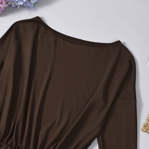 Detailed view of dark brown off-shoulder knit dress with elastic waist on grey background