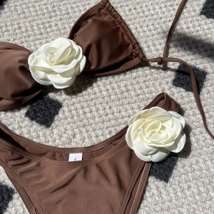 Close-up of brown drawstring bikini with white 3D satin rose and size S label detail