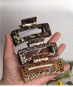 Detail of leopard print rectangular hair claws in green, grey, and yellow acetate finish