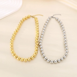 Détail de colliers à perles creuses de 12 mm en finitions or et argent avec chaîne ajustable