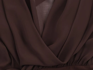 Dettaglio del tessuto in chiffon marrone scuro con eleganti pieghe in stile a portafoglio