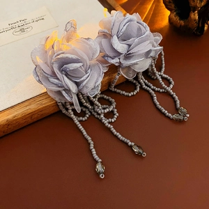 Detail of fabric flower earrings with beaded tassels and delicate lavender mesh petals