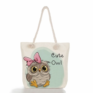 Detail of beige canvas tote bag featuring cute owl print and thick rope handles