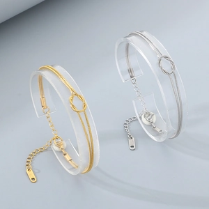 Detail of minimalist double-layered snake chain knot bracelets in gold and silver finish