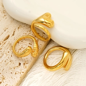Three-piece gold minimalist geometric rings set with heart and textured bands on stone