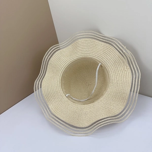 Detail of hand-woven straw sun hat showing wavy brim and triple translucent mesh stripes