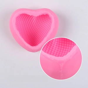 Detail of pink heart silicone mold featuring intricate mesh texture for DIY candle making