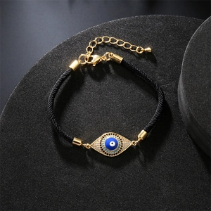 Detailed close-up of evil eye bracelet with micro-pave zircons and black woven cord