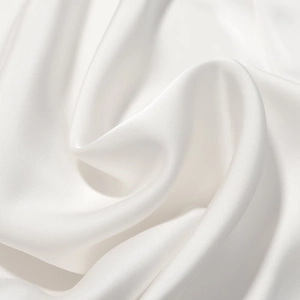 Vue détaillée montrant la texture lisse et l'éclat élégant du tissu en satin blanc