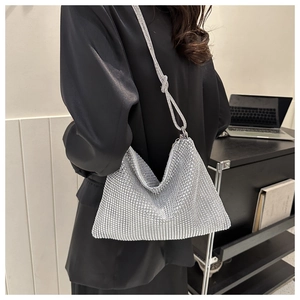 Detail of silver rhinestone tote bag showing knotted strap and sparkling crystal surface