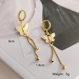 Detail of 18K gold butterfly tassel earrings featuring zircon inlay and sleek metal chains