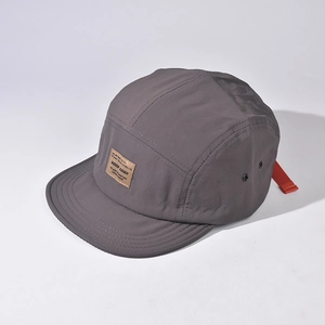 Detail view of a grey short brim outdoor quick-dry hat showing breathable fabric and orange strap