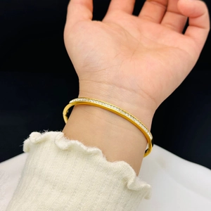 Elegant gold titanium bangle with sparkling zircon pavé setting shown on wrist