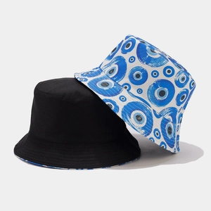 Dettaglio di cappelli a secchiello in cotone bianco e nero con ricamo occhio greco