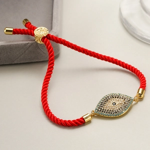 Detailed shot of evil eye red cord bracelet with gold accents and zircon inlay