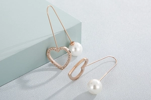 Detail of rose gold heart earrings featuring sparkling crystals and white pearls