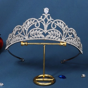 Exquisite silver bridal crown featuring leaf motifs and rhinestones on a display stand