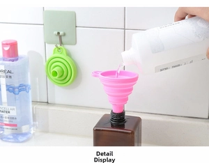 Dettaglio degli imbuti pieghevoli in silicone rosa e verde con foro di sospensione per cucina