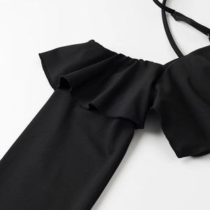 Dettaglio della trama in maglia nera con bordi a balze su un crop top minimalista nero