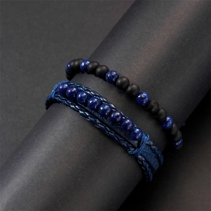 Macro shot of two-piece set featuring black frosted beads and blue leather braided bracelet