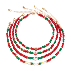Set of four Christmas colorful clay bead necklaces with festive pendants on white background