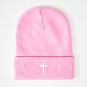 Pink ribbed knit beanie featuring a white cross embroidery and a wide folded cuff