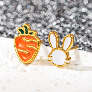 Gros plan sur les boucles d'oreilles carotte et lapin en acier inoxydable doré et émail
