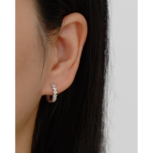 Close-up of s925 silver hoop earring with sparkling clear zircons worn by a model